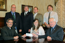Thomas P. Cummings, seated right, from the Friendly Sons of St. Patrick of Lackawanna County’s Dr. John Corcoran Scholarship Committee, presents a check to University of Scranton President Kevin P. Quinn, S.J., seated far left, and this year’s scholarship recipient, University of Scranton student Greylan Heffernan, seated center, in support of her study abroad in Galway, Ireland. Standing, from left, representing the Friendly Sons of St. Patrick of Lackawanna County, are John L. Walker, president, Patrick J Cummings, vice president, and Robert J. Lynett, assistant treasurer; and Michael R. Simons, director of study abroad and global initiatives at The University of Scranton.